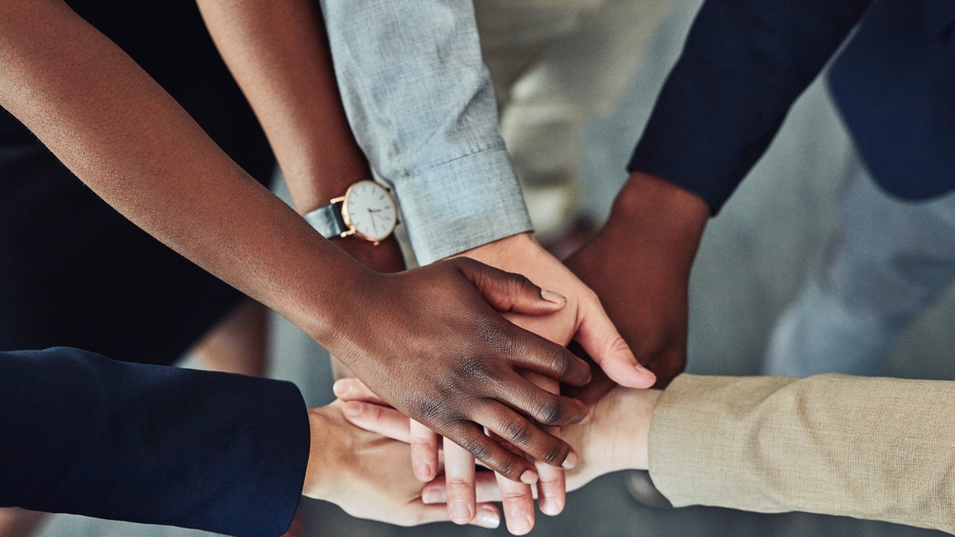 Team putting hands together in unity